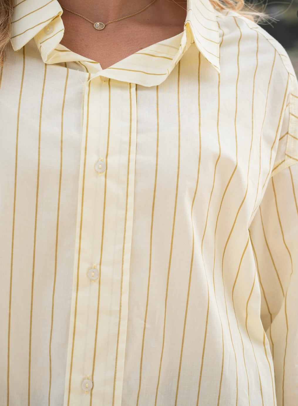 Oversized collared shirt in lemon tan showing longline fit and scooped hem