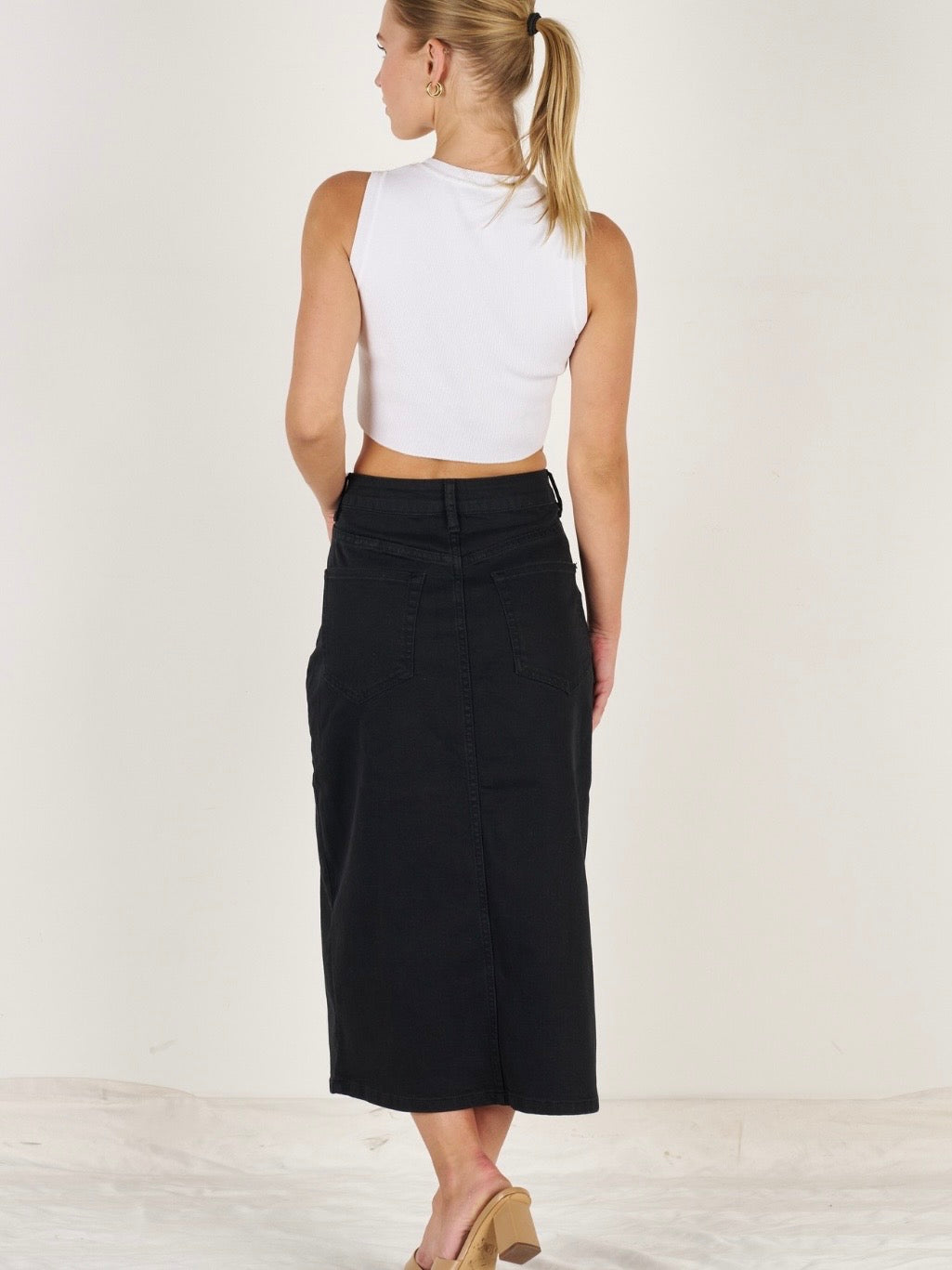 Black denim long skirt showing midi length and button zip closure