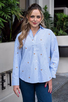 Blue striped shirt showing embroidered star detail and hi-lo hem