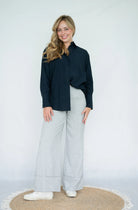 Navy blue collared shirt showing relaxed straight fit and curved hem