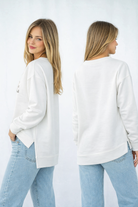 Womans white sweatshirt and light blue jeans, shown from front and back. Highlow hem line split in side crew neck